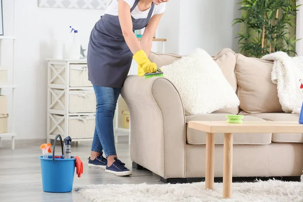 Žena údržbář úklid nábytku na pokoji — Stock fotografie