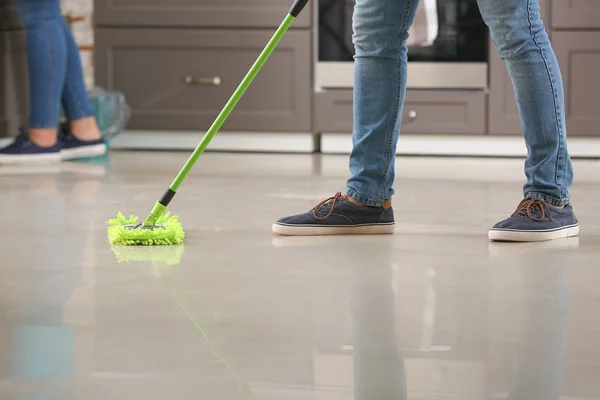 Чоловічий прибиральник обмотує підлогу на кухні — стокове фото