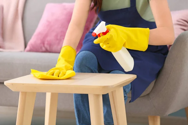 Hausmeisterin putzt Tisch im Zimmer — Stockfoto