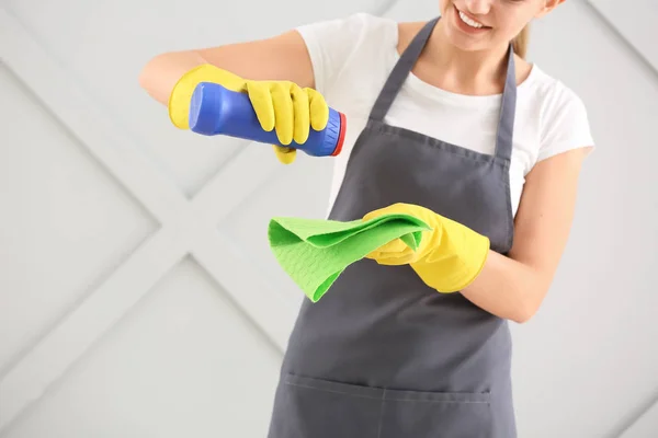 Γυναίκα επιστάτης με προμήθειες καθαρισμού σε γκρι φόντο — Φωτογραφία Αρχείου