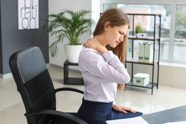 Joven mujer de negocios que sufre de dolor de espalda en el cargo — Foto de Stock