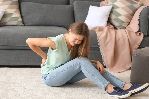 Young woman suffering from back pain at home — Stock Photo, Image