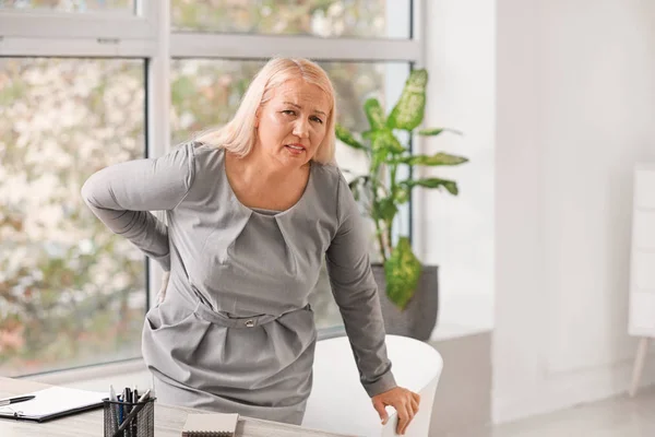 사무실에서 허리 통증으로 고생하는 장성 한 여자 — 스톡 사진