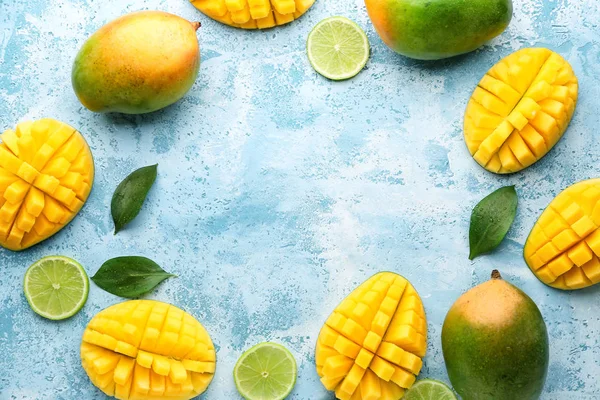 Marco hecho de mangos maduros dulces y cal sobre fondo de color — Foto de Stock