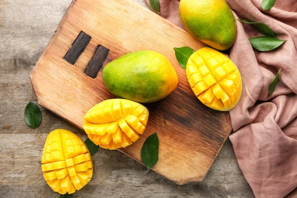 Tahta kesmek ve masada olgun mangolar.