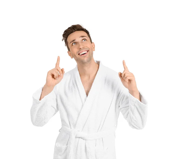 Hombre guapo en bata de baño apuntando a algo sobre fondo blanco — Foto de Stock