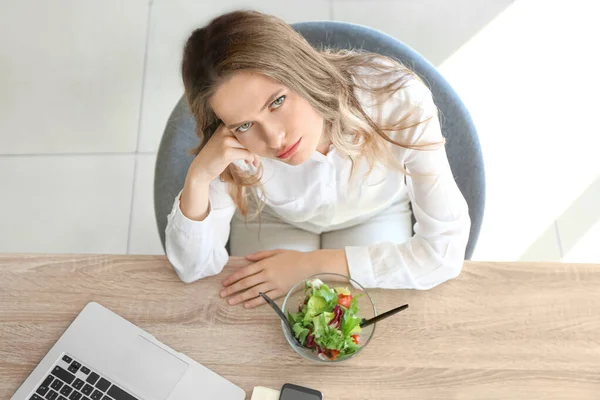 Mujer triste con ensalada de verduras saludables en la oficina —  Fotos de Stock