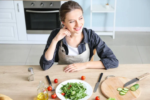 Mujer con sabrosa ensalada de verduras en la cocina —  Fotos de Stock