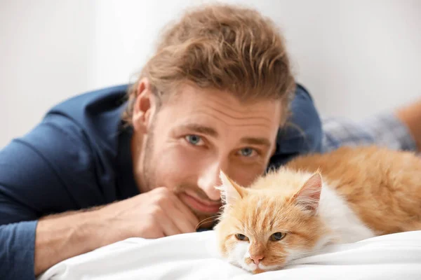 Man with cute cat in bedroom — Stock Photo, Image