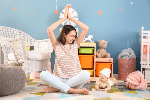 Joven madre con bebé meditando en casa —  Fotos de Stock
