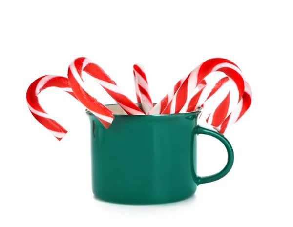 Tazza con bastoncini di zucchero natalizio su sfondo bianco — Foto Stock