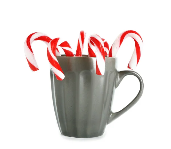 Mug with Christmas candy canes on white background — Stock Photo, Image