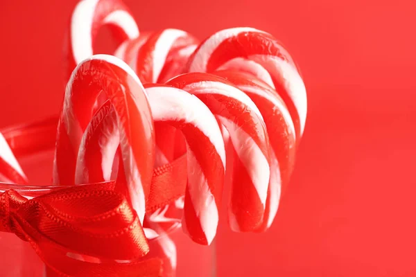 Glass with Christmas candy canes on color background, closeup — Stock Photo, Image