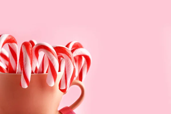 Taza con bastones de caramelo de Navidad en el fondo de color, primer plano — Foto de Stock