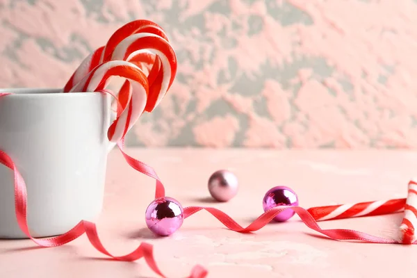 Mug with Christmas candy canes on table — Stock Photo, Image