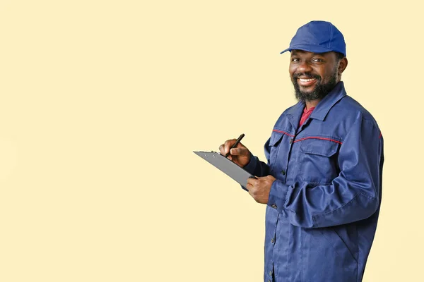 African-American car mechanic on color background — Stock Photo, Image