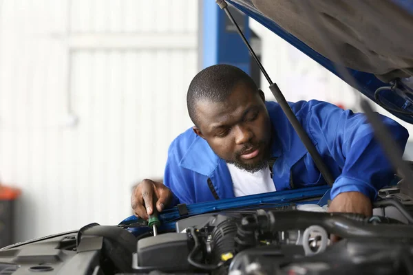 African-American mechanic working in car service center