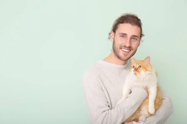 Uomo con gatto carino su sfondo di colore — Foto Stock