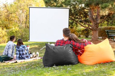 Arkadaşlar açık hava sinemasında film izliyor.