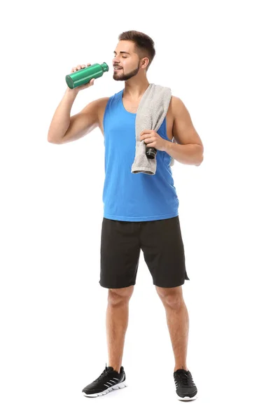 Sporty young man with towel and bottle of water on white background — Stock Photo, Image