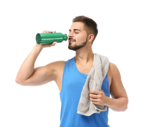 Sporty young man with towel and bottle of water on white background — Stock Photo, Image