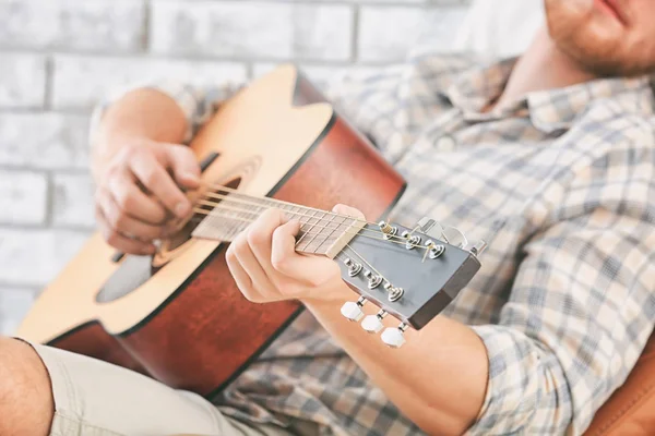 Bonito homem tocando guitarra em casa, close-up — Fotografia de Stock