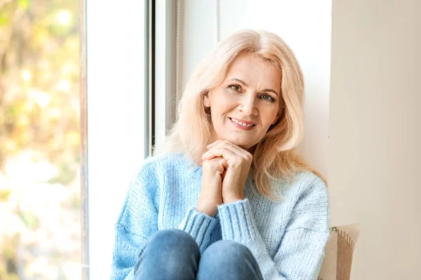 Portrait of beautiful mature woman near window — Stock Photo, Image