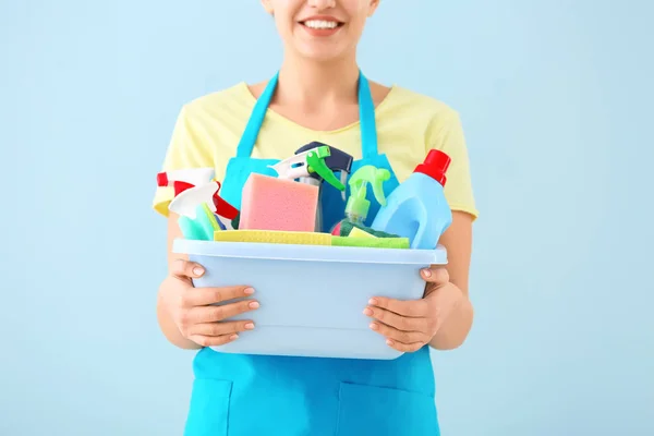 Femme concierge avec des fournitures de nettoyage sur fond de couleur — Photo