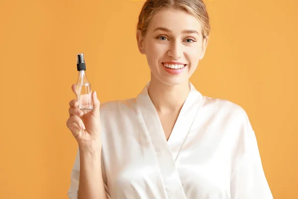 Vacker ung kvinna med kosmetisk produkt på färg bakgrund — Stockfoto