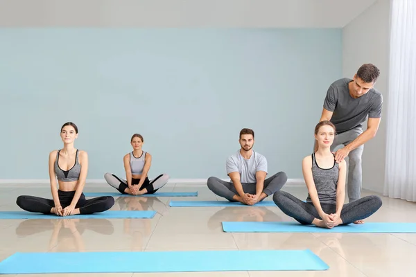 Group of people practicing yoga with instructor in gym — Stock Photo, Image