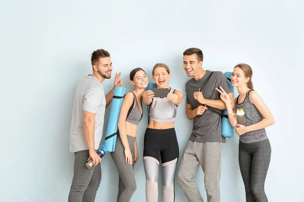 Groep van mensen met yoga matten nemen selfie in de buurt van kleur muur — Stockfoto