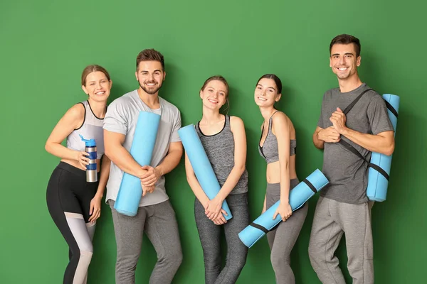 Groep mensen met yoga matten in de buurt van kleur muur — Stockfoto