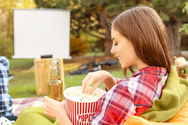 Young woman with popcorn in outdoor cinema — Stock Photo, Image