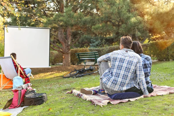 Young couple watching movie in outdoor cinema — Stock Photo, Image