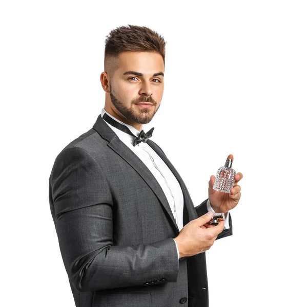 Schöner junger Mann mit einer Flasche Parfüm auf weißem Hintergrund — Stockfoto