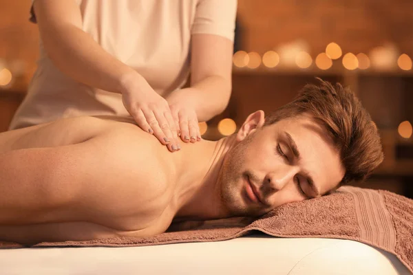 Handsome young man receiving massage in spa salon — Stock Photo, Image