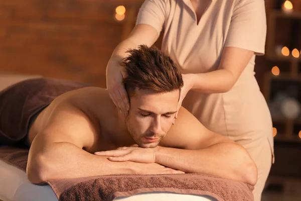 Handsome young man receiving massage in spa salon — Stock Photo, Image