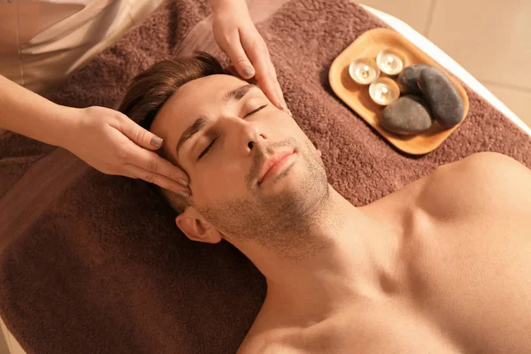 Handsome young man receiving massage in spa salon — Stock Photo, Image