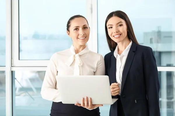 Vackra affärskvinnor med bärbar dator diskuterar frågan i ämbetet — Stockfoto