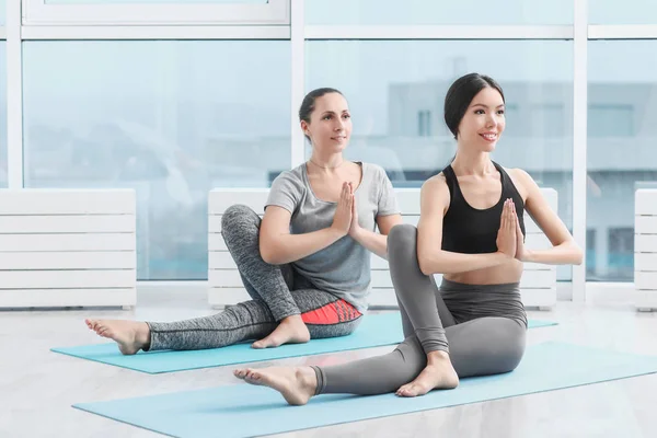 Sportovní mladé ženy cvičí jógu v tělocvičně — Stock fotografie