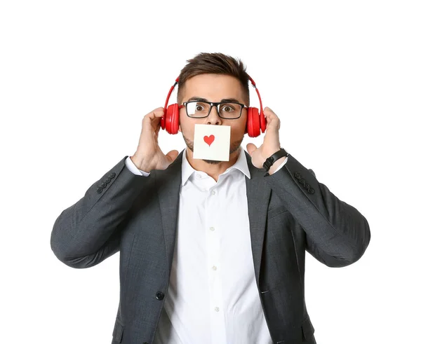 Hombre guapo con auriculares y tarjeta de felicitación sobre fondo blanco. Celebración de San Valentín —  Fotos de Stock