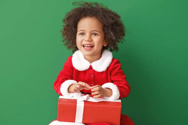 穿着圣诞老人服装，拥有彩色背景礼物的非洲裔美国小女孩 — 图库照片