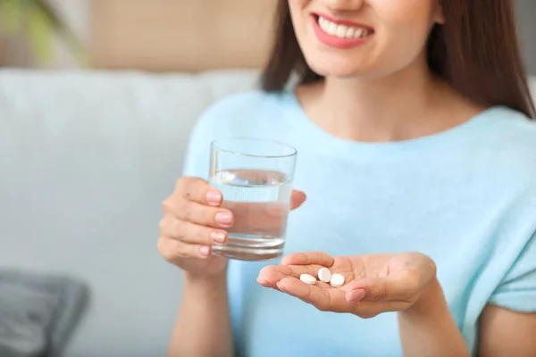 Jonge vrouw die thuis medicijnen neemt — Stockfoto