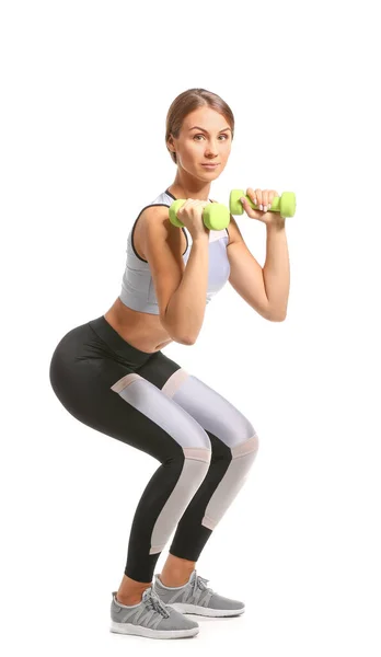 Sportovní mladá žena s činkami na bílém pozadí — Stock fotografie