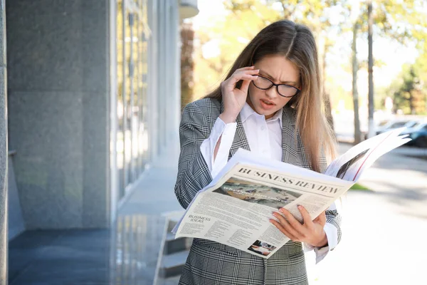 Young businesswoman with newspaper outdoors — Stock Photo, Image