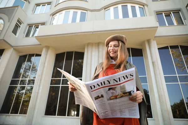 Mujer joven con periódico al aire libre —  Fotos de Stock
