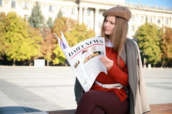 Young woman with newspaper outdoors — Stock Photo, Image