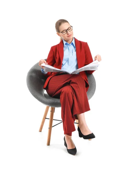 Joven empresaria con periódico sentada en sillón sobre fondo blanco — Foto de Stock