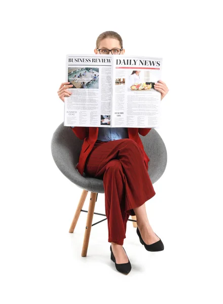 Young businesswoman with newspaper sitting in armchair against white background — Stock Photo, Image
