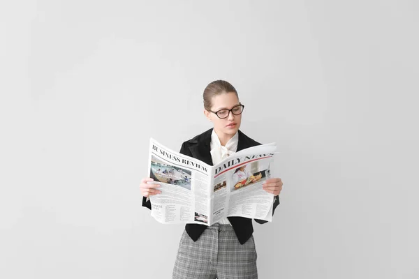 Joven empresaria con periódico sobre fondo claro — Foto de Stock